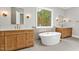 Elegant bathroom with double vanities, a freestanding tub, and wood cabinets at 503 Damascus Church Rd, Chapel Hill, NC 27516