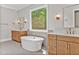 Spa-like bathroom with double vanities, a large soaking tub, and wood cabinets at 503 Damascus Church Rd, Chapel Hill, NC 27516