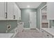 Bright laundry room with white cabinets, patterned tile floor, and access to a walk-in closet at 503 Damascus Church Rd, Chapel Hill, NC 27516