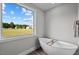 Bathroom with freestanding bathtub and a window overlooking the backyard at 4566 Ashtons Way, Franklinton, NC 27525