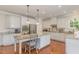 Updated kitchen with white cabinets, granite island, and stainless steel appliances at 1329 Endgame Ct, Wake Forest, NC 27587
