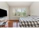 Spacious main bedroom with large windows, hardwood floors, and a comfortable bed at 1329 Endgame Ct, Wake Forest, NC 27587
