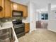 Galley kitchen with wood cabinets, stainless steel appliances, and tile flooring at 320 Gilman Ln # 110, Raleigh, NC 27610
