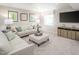Finished basement with sectional sofa, ottoman, and media console at 8805 Tartan Clan Dr, Willow Springs, NC 27592