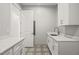 Bright laundry room with white cabinets, quartz countertops, and patterned tile floor at 111 November Dr, Durham, NC 27712