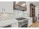Modern kitchen features a range, custom hood, and white cabinetry at 111 November Dr, Durham, NC 27712