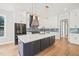Modern kitchen with white cabinets, a large island, and blue tile backsplash at 109 November Dr, Durham, NC 27712