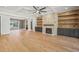 Open living room featuring hardwood floors, a stone fireplace, and built-in shelving at 109 November Dr, Durham, NC 27712