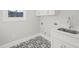 Laundry room with white cabinets, quartz countertop, and patterned tile floor at 109 November Dr, Durham, NC 27712