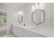 Double vanity bathroom with hexagonal mirrors and white cabinets at 109 November Dr, Durham, NC 27712