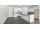 Modern kitchen boasts white cabinets, granite island, and gray flooring at 863 Old Tarboro Rd, Wendell, NC 27591
