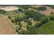 Aerial view of a house on a large lot with surrounding trees and fields at 113 Amelia Ln, Holly Springs, NC 27540