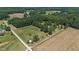 Aerial view of a property with a house, outbuildings, and extensive land at 113 Amelia Ln, Holly Springs, NC 27540