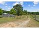 Gravel driveway entrance to the property with wooden fencing at 113 Amelia Ln, Holly Springs, NC 27540