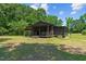 Rustic cabin with covered porch and rocking chairs, nestled in a wooded setting at 113 Amelia Ln, Holly Springs, NC 27540