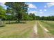 Long gravel driveway meandering through a lush green landscape at 113 Amelia Ln, Holly Springs, NC 27540