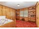 Cozy bedroom with wood-paneled walls and built-in shelving at 8450 Perry Rd, Graham, NC 27253
