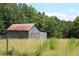 Rustic barn with a rusty metal roof at 8450 Perry Rd, Graham, NC 27253