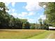 Open field with tall grass and trees in the background at 8450 Perry Rd, Graham, NC 27253