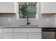 Modern kitchen sink with gray tile backsplash and granite countertop at 1844 Brier Ln, Graham, NC 27253