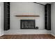 White brick fireplace with wood mantel and black shelving at 1844 Brier Ln, Graham, NC 27253