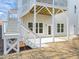 A white staircase leads down to the backyard patio under a raised porch at 112 Pointe Park Cir # 96, Holly Springs, NC 27540