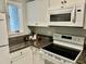 Modern white kitchen with granite countertops and stainless steel appliances at 710 M.L.K. Jr Blvd # F4, Chapel Hill, NC 27514