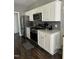 Modern kitchen with white cabinets, stainless steel appliances, and marble countertops at 970 Southern High School Rd, Graham, NC 27253