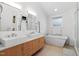 Modern bathroom with double sinks, a soaking tub, and a walk-in shower at 617 Tower St, Raleigh, NC 27607