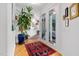Light-filled entry hall with hardwood floors, large plant, and access to backyard at 617 Tower St, Raleigh, NC 27607