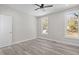 Bright bedroom with wood-look floors, ceiling fan, and two large windows at 531 Booth St, Roxboro, NC 27573