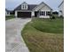 Beige house with brown accents, double garage, and green lawn at 32 Scotties Ridge Dr, Princeton, NC 27569