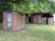 Brick outbuilding and red barn with wooden fence at 3124 Raleigh Rd, Henderson, NC 27537