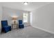 Spacious bedroom with two blue chairs and a window at 541 Henham Way, Zebulon, NC 27597
