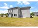 Two-story house with gray siding, spacious backyard, and a patio at 541 Henham Way, Zebulon, NC 27597