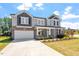 Two-story house with gray siding, stone accents, and a front porch at 541 Henham Way, Zebulon, NC 27597