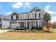 Two-story house with gray siding, stone accents, and a front porch at 541 Henham Way, Zebulon, NC 27597