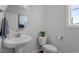 Modern powder room with pedestal sink, toilet, and decorative accents at 541 Henham Way, Zebulon, NC 27597