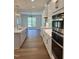 Open concept kitchen with white cabinets, quartz counters, and hardwood floors at 200 Whistlers Cv, Louisburg, NC 27549