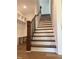 Elegant staircase with dark wood railings and white risers leading to the upper level at 200 Whistlers Cv, Louisburg, NC 27549