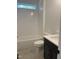 Modern bathroom with a white tiled shower/tub combo, dark vanity, and grey floor tiles at 200 Whistlers Cv, Louisburg, NC 27549