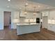 Modern kitchen features white cabinets, a center island, and stainless steel appliances at 200 Whistlers Cv, Louisburg, NC 27549