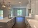 Bright kitchen boasts white cabinets, quartz countertops, and a large island at 200 Whistlers Cv, Louisburg, NC 27549