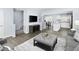 Open living room and kitchen with grey sofas and hardwood floors at 4507 Black Drum Dr, Raleigh, NC 27616