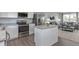 Open kitchen with island, stainless steel appliances, and hardwood floors at 4511 Black Drum Dr, Raleigh, NC 27616