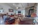 Spacious living room featuring hardwood floors, a stone fireplace, and comfortable leather furniture at 468 Loftis Loop Rd, Roxboro, NC 27574