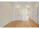 Empty bedroom with hardwood floors, double doors, and open doorway to hallway at 1641 Legacy Ridge Ln, Wake Forest, NC 27587