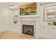 Fireplace with built-in shelving, wood floors, and modern artwork at 1641 Legacy Ridge Ln, Wake Forest, NC 27587