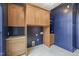 Spacious laundry room with wood cabinets, navy blue walls, and tile flooring at 1641 Legacy Ridge Ln, Wake Forest, NC 27587