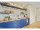 Stylish wet bar with blue cabinetry, wood countertop, and exposed brick backsplash at 1641 Legacy Ridge Ln, Wake Forest, NC 27587